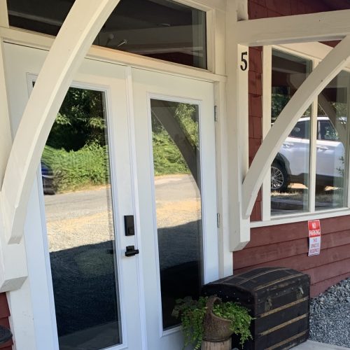CC-01-02 - Club Car private entrance featuring modern double French doors, heritage industrial architecture, and a vintage travelers trunk to welcome you